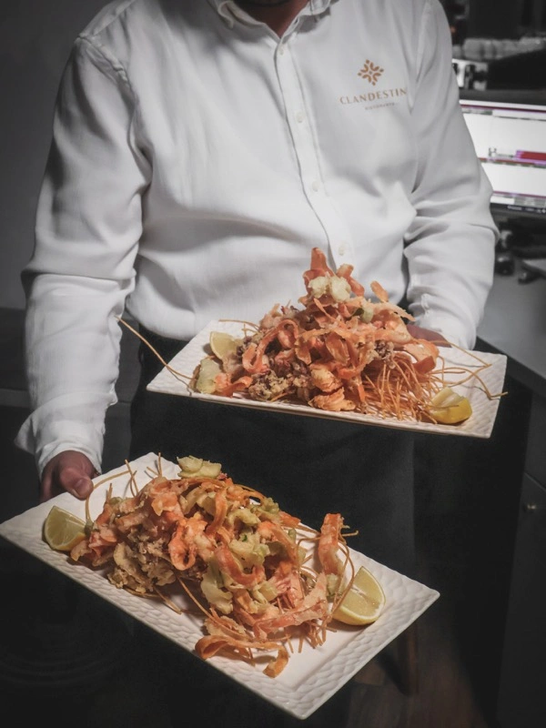 Stafi me bluzën Clandestino dhe pjata me friturë deti